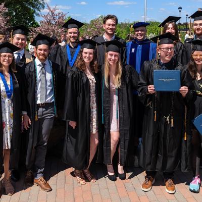 group of geology graduates with Dr. Scott Clark, all in gowns 